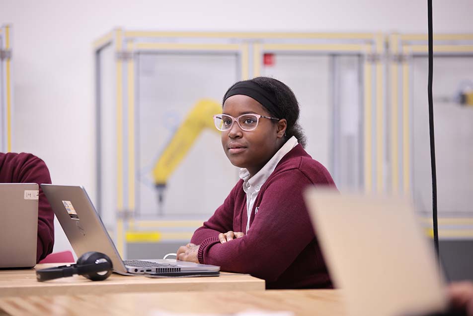 student in classroom smiling at camera
